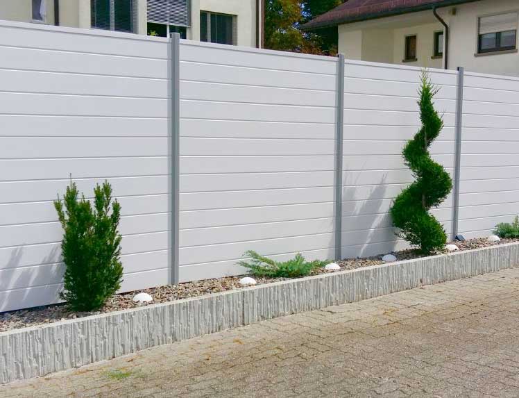 Sichtschutzzaun aus Kunststoff PVC  in weiß mit Aluminium Steckpfosten im Garten